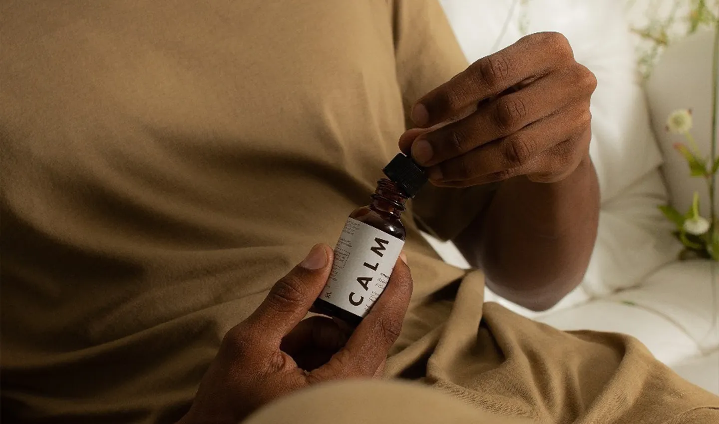 A person holding a bottle of Calm by Psyched Wellness