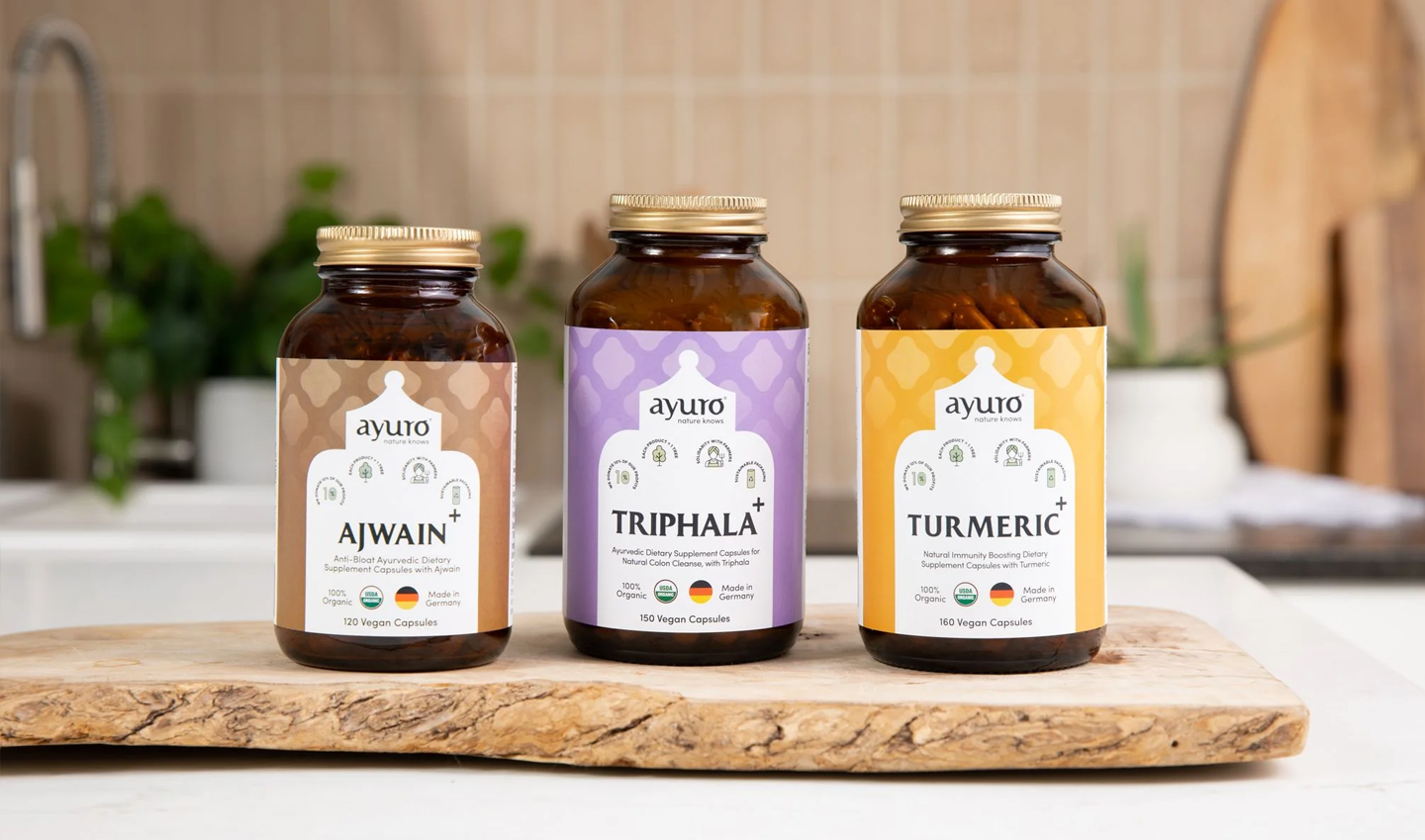 3 bottles of ayuro supplements next to each other on a wooden slab on a kitchen counter top